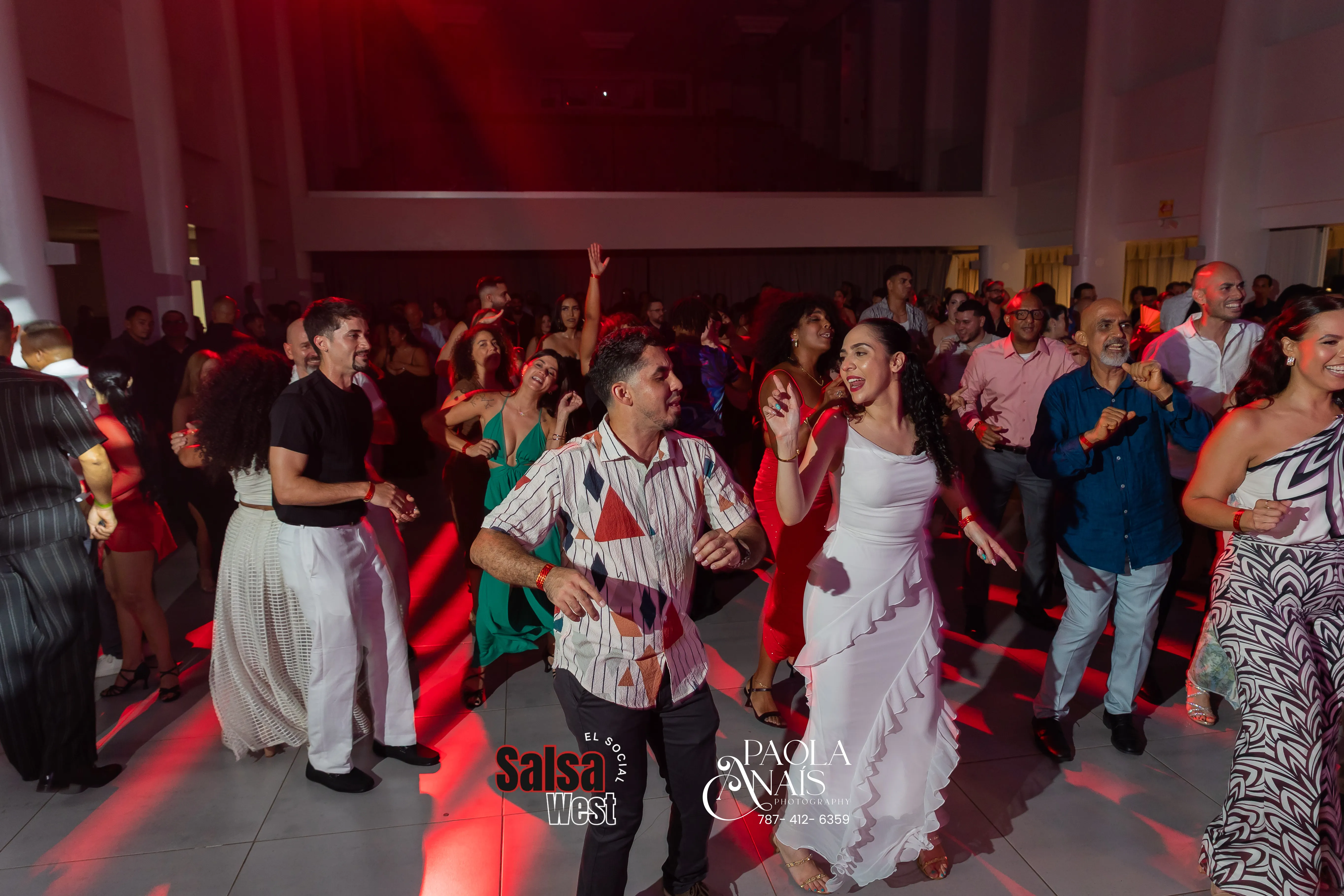Multitud bailando salsa en la plaza con orquesta en vivo